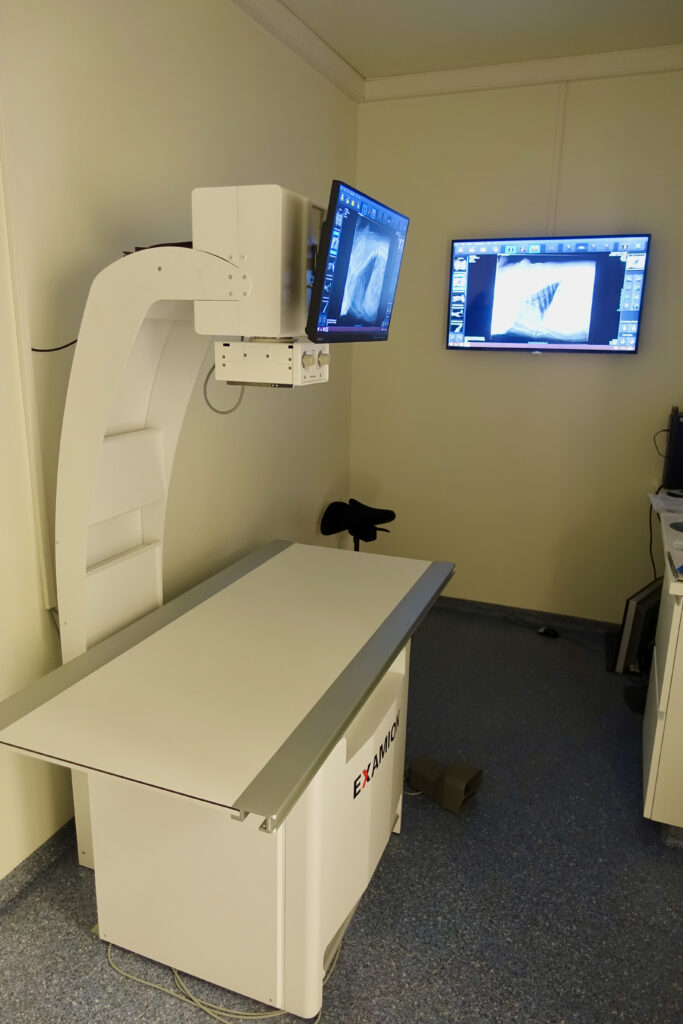 X-ray room at the veterinary clinic with examination table and screens; the floor is blue-grey acrylic coating